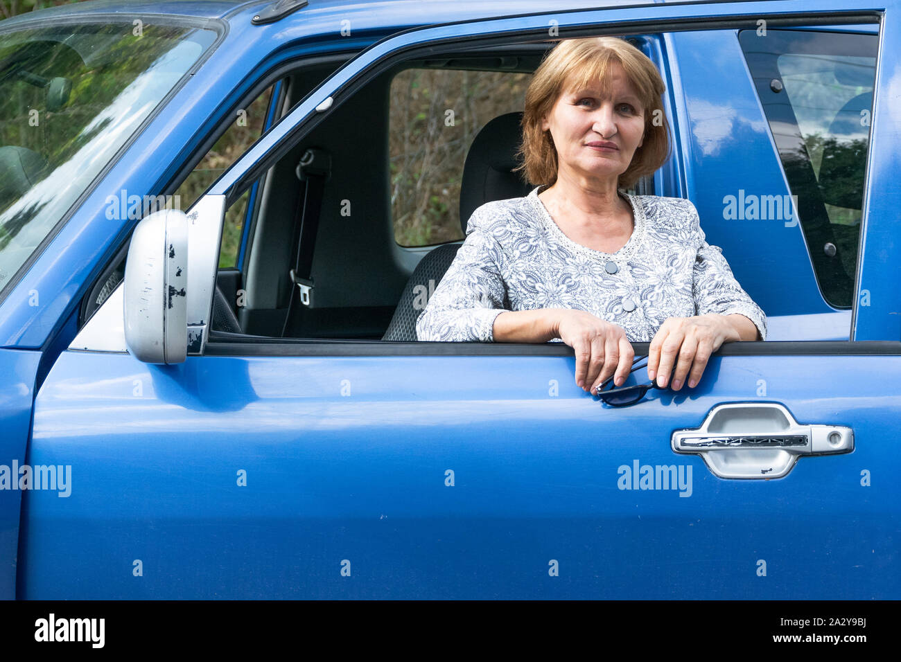 Attractive senior dame voyageant avec l'automobile. Concept de vie actif Banque D'Images