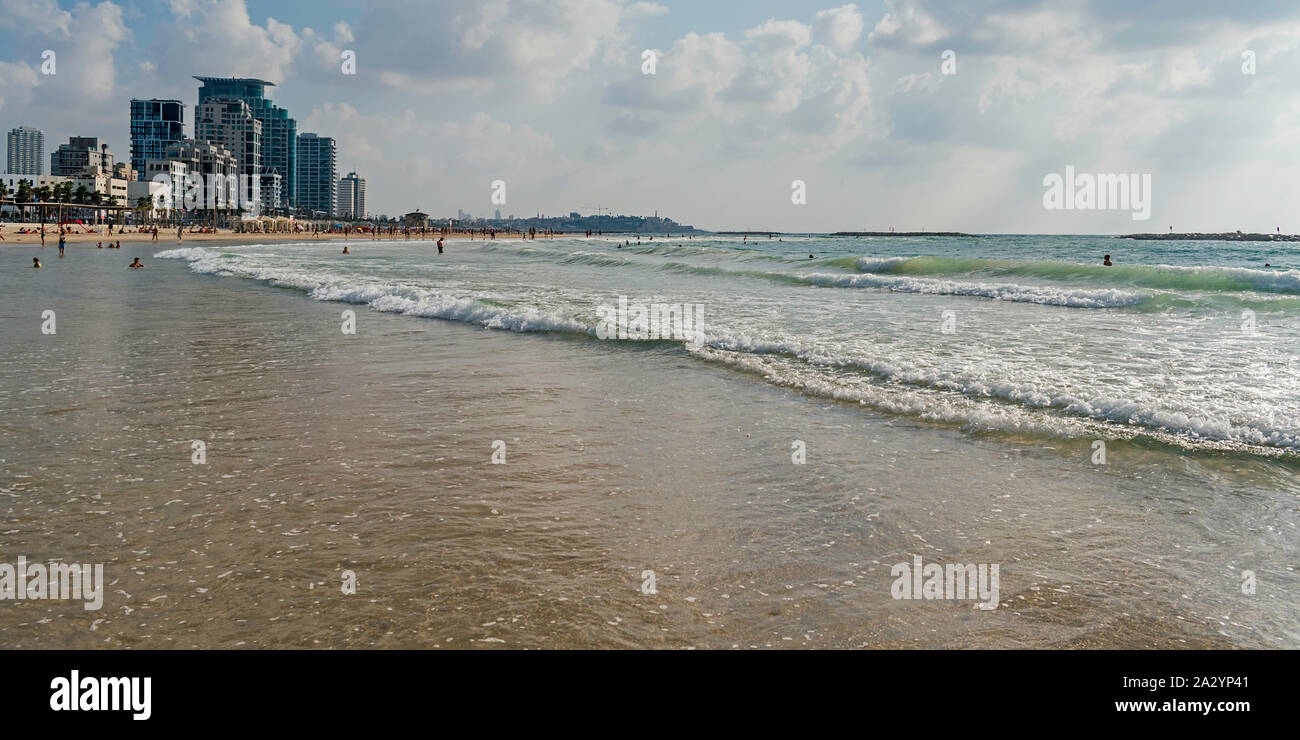Les baigneurs et les touristes appréciant un temps parfait sur une plage de Tel Aviv avec resort hôtels et port de jaffa dans l'arrière-plan Banque D'Images