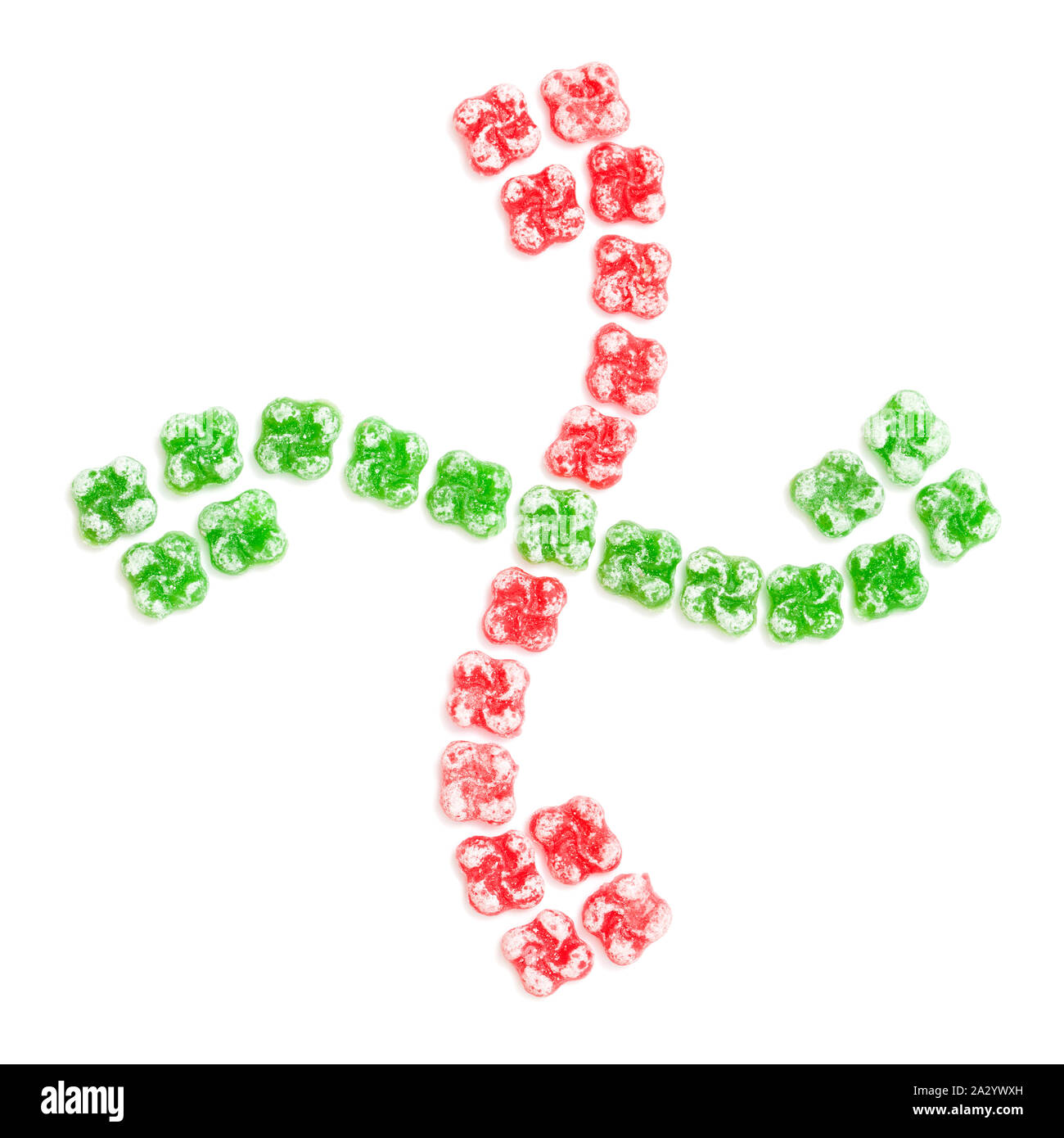 Bonbons durs en forme de croix Basque, lauburu, disposés dans la même forme, isolé sur fond blanc Banque D'Images