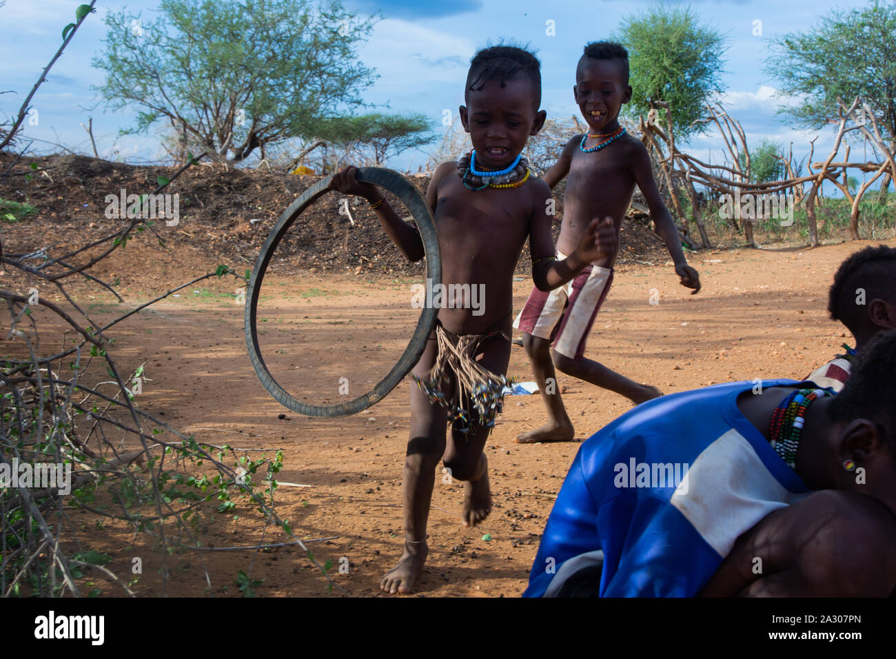 Turmi, Éthiopie - Nov 2018 : tribu Hamer enfants jouant avec le pneu. L'un chasse l'autre. Vallée de l'Omo Banque D'Images