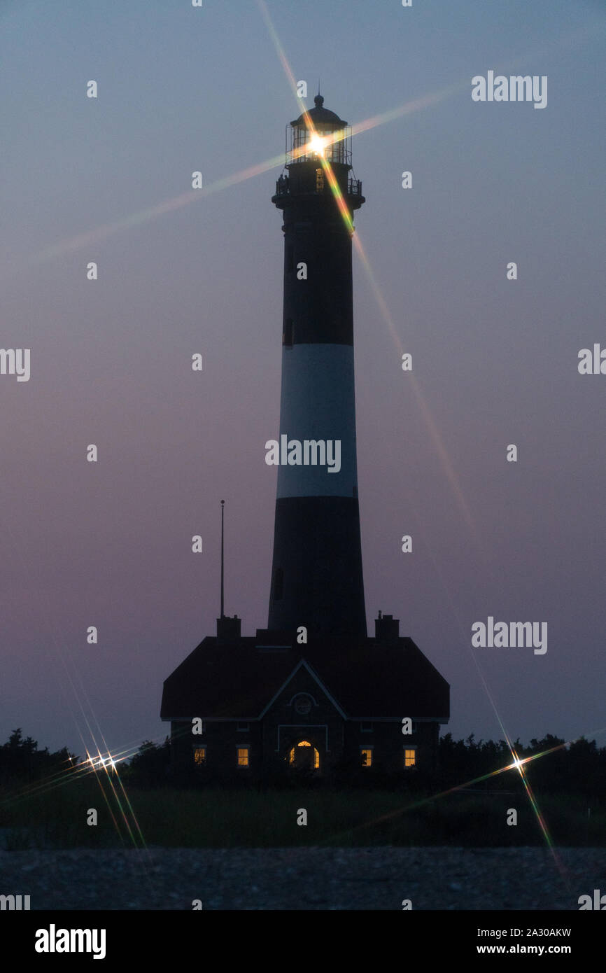 Fire Island phare croix étoile effet brillant gyrophare sur Robert Moses beach de nuit sur le rivage pour la signalisation des bateaux océan tra Banque D'Images