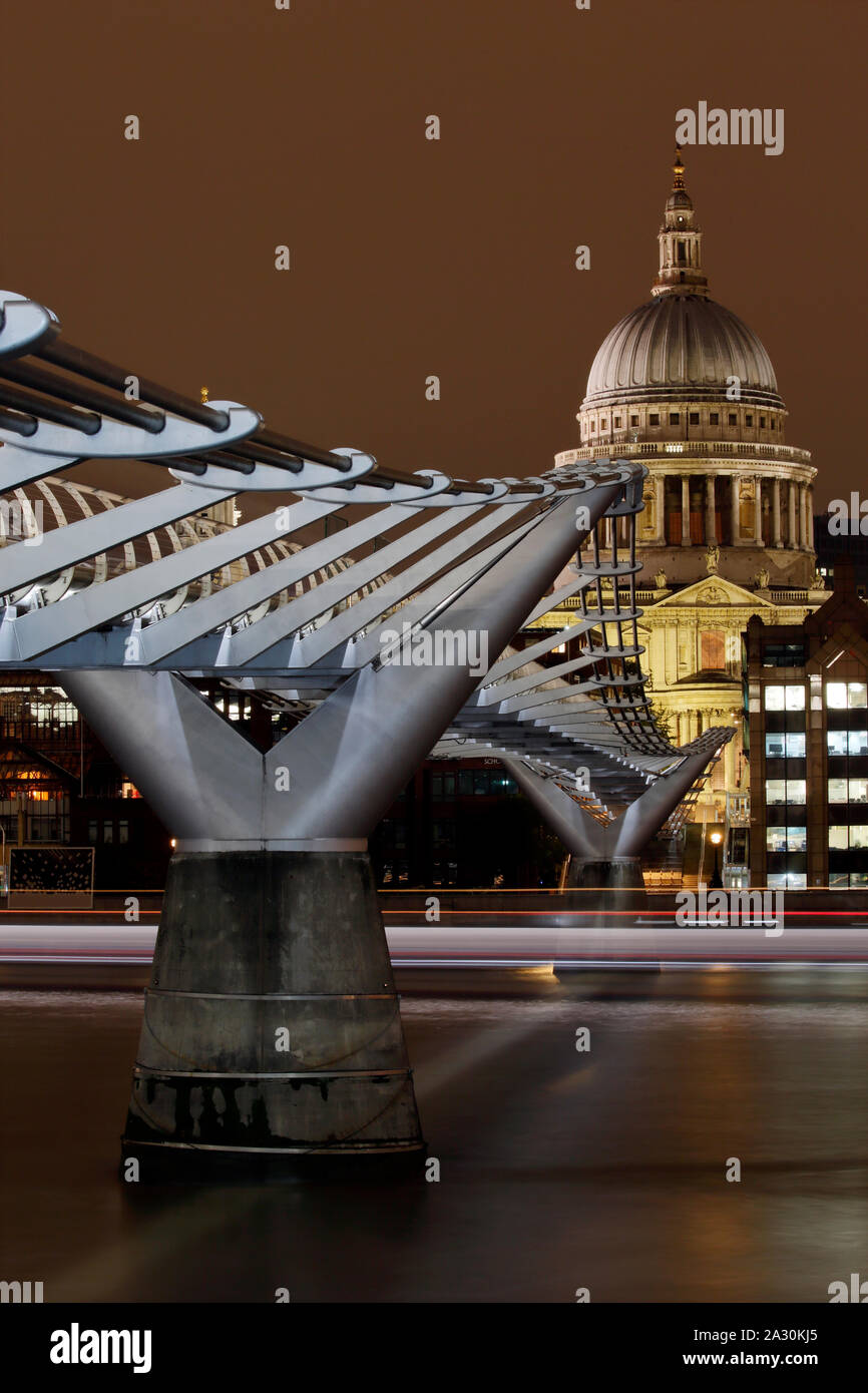Le Millennium Bridge et de Saint Pauls Cathedral, Londres, Angleterre la nuit, avec la lumière des sentiers de bateaux de passage, une longue exposition de droit. Banque D'Images