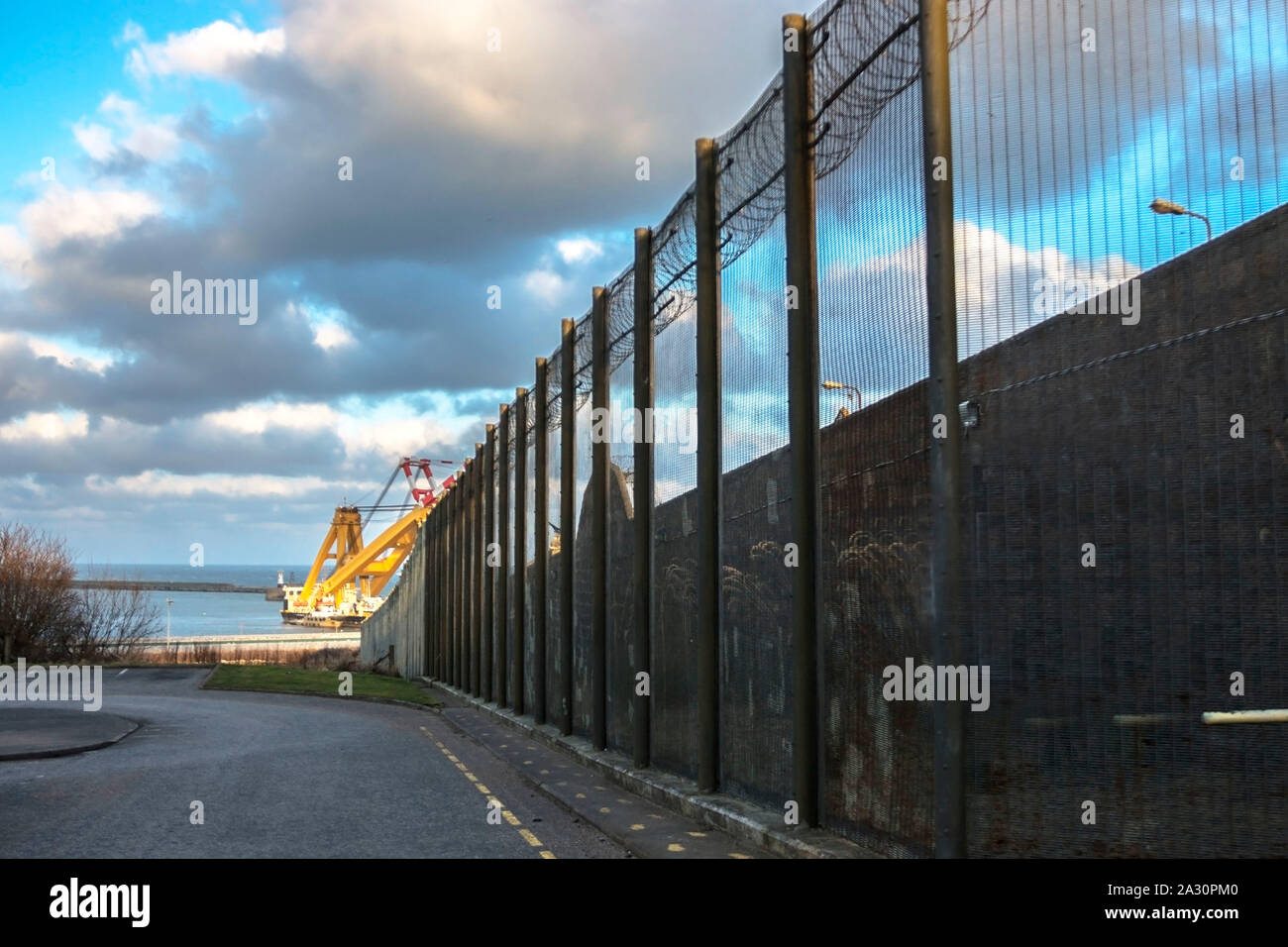 Les murs des prisons et une clôture avec crampons sur le fond de ciel bleu. Le Musée de la prison de Peterhead, Aberdeenshire, Ecosse, Royaume-Uni. Banque D'Images