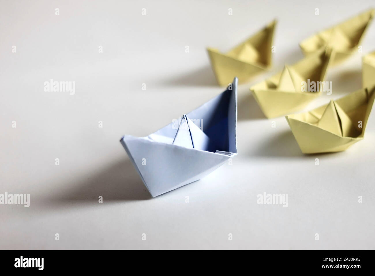 Concept de leadership. Bateaux en papier sur un fond blanc. Leader avant d'autres créations en papier, et l'origami. Banque D'Images