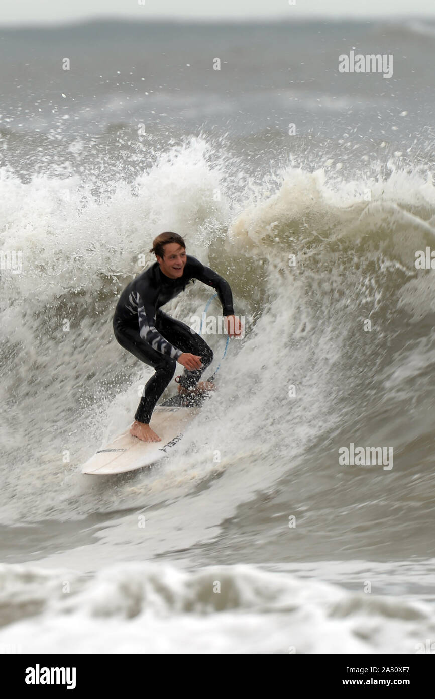 Les courses de surfer une vague déferlante avec délice sur son visage Banque D'Images