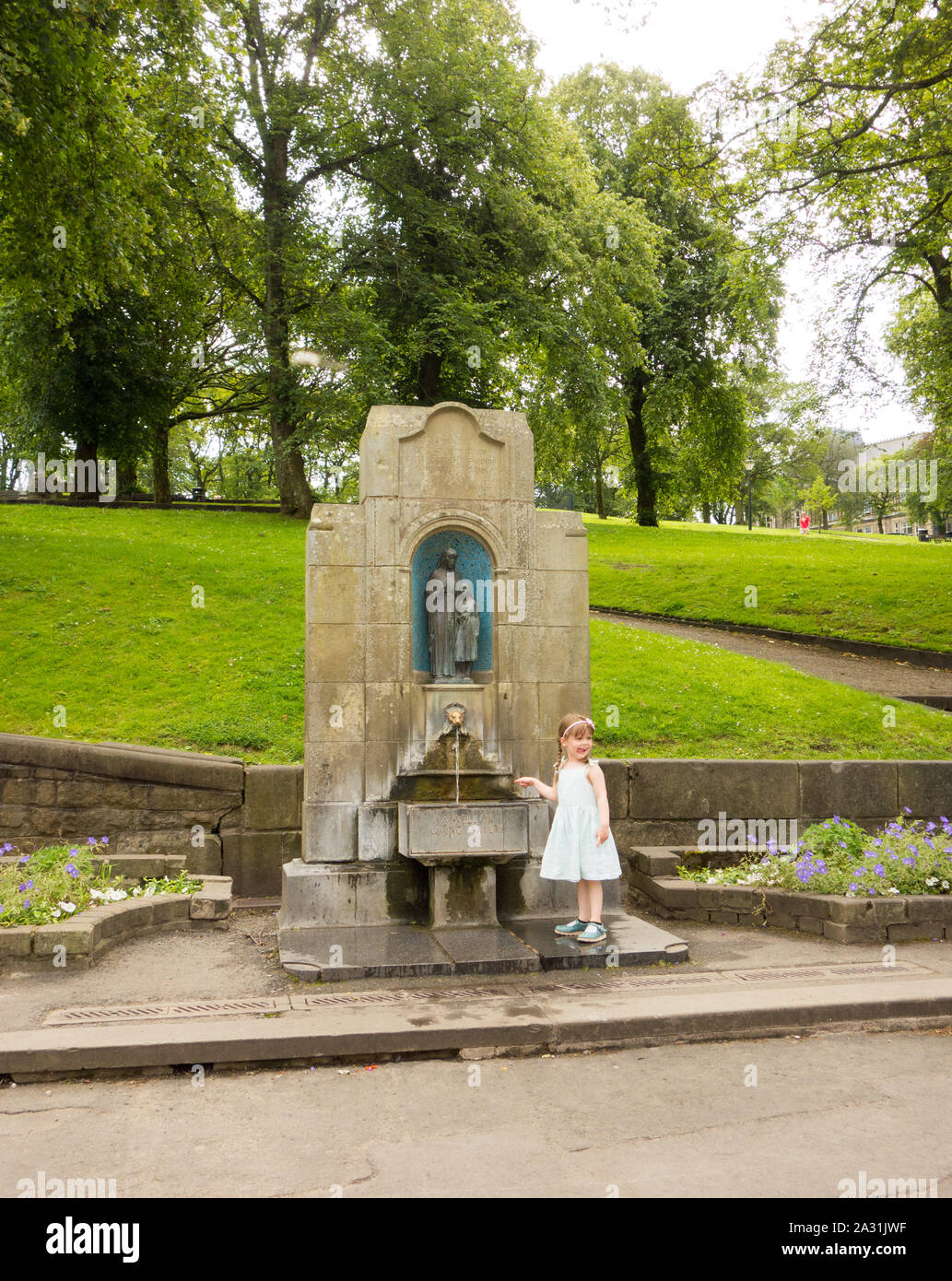 Jeune fille par Buxton permanent de l'eau de source de St Anne's bien dans la ville thermale de Buxton Derbyshire, Angleterre Banque D'Images