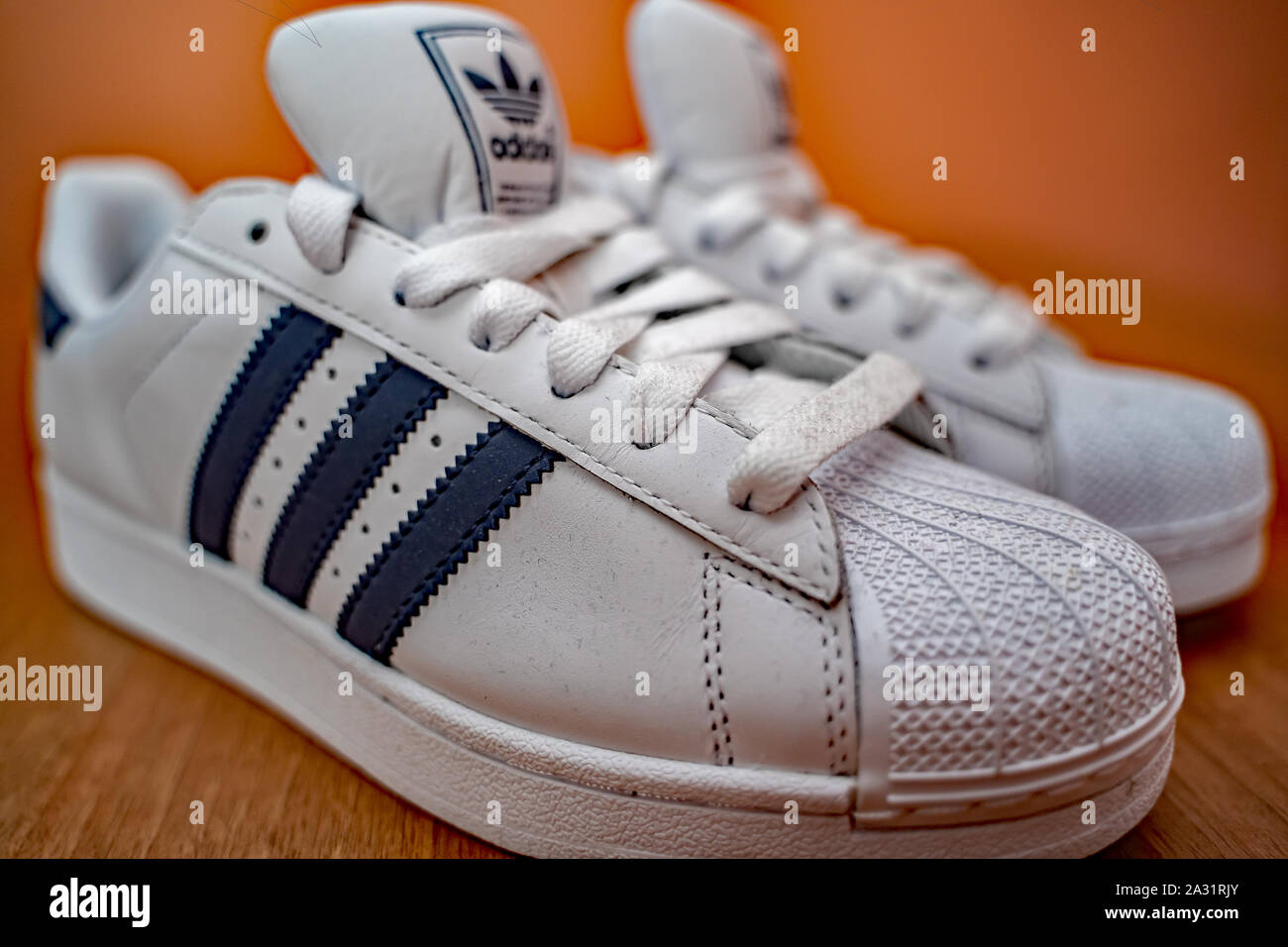 Gros plan d'une paire de blanc Adidas formateurs avec trois rayures bleues Banque D'Images