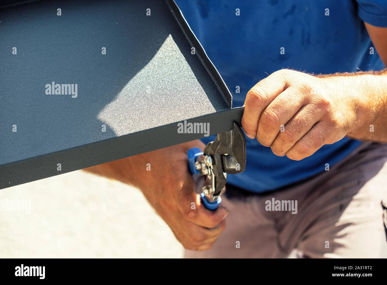 Worker cutting la tôle de solin avec mains ciseaux Banque D'Images