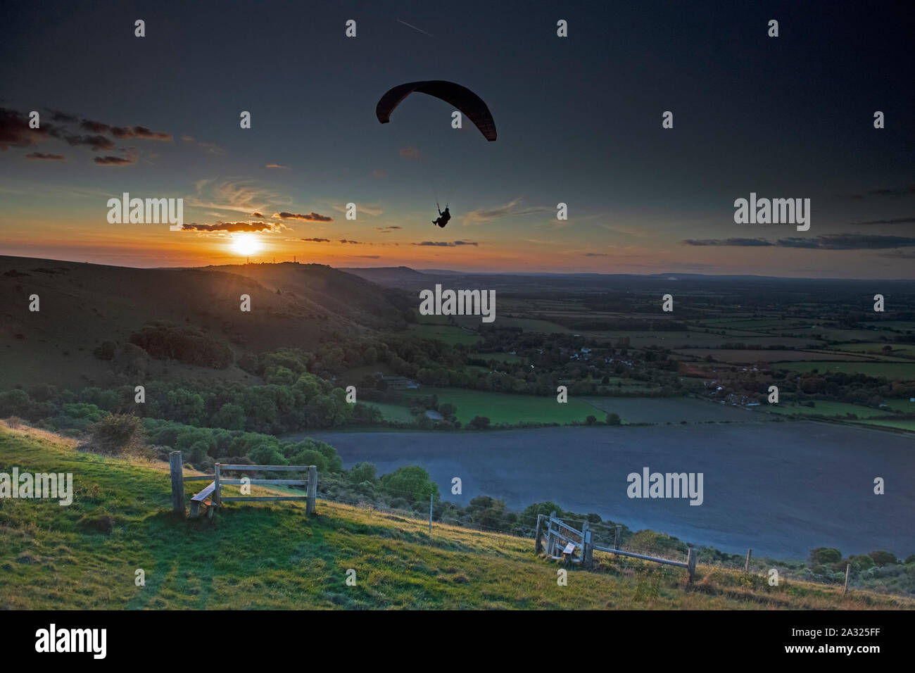 Un homme paraglides sur le Parc National du Sud pendant le coucher du soleil. Uk Banque D'Images