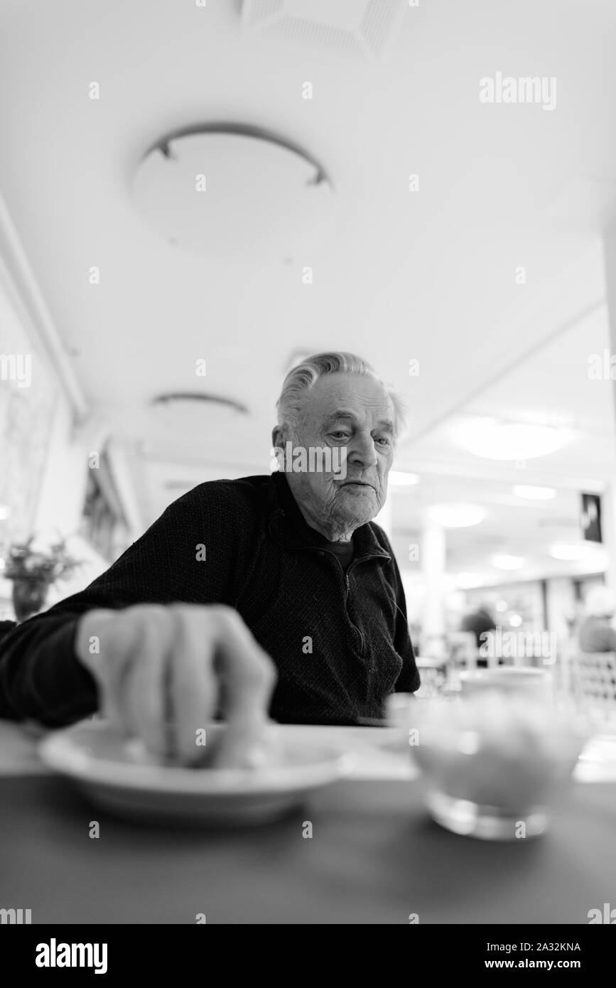 Man manger à la cafétéria de la maison de soins infirmiers Banque D'Images