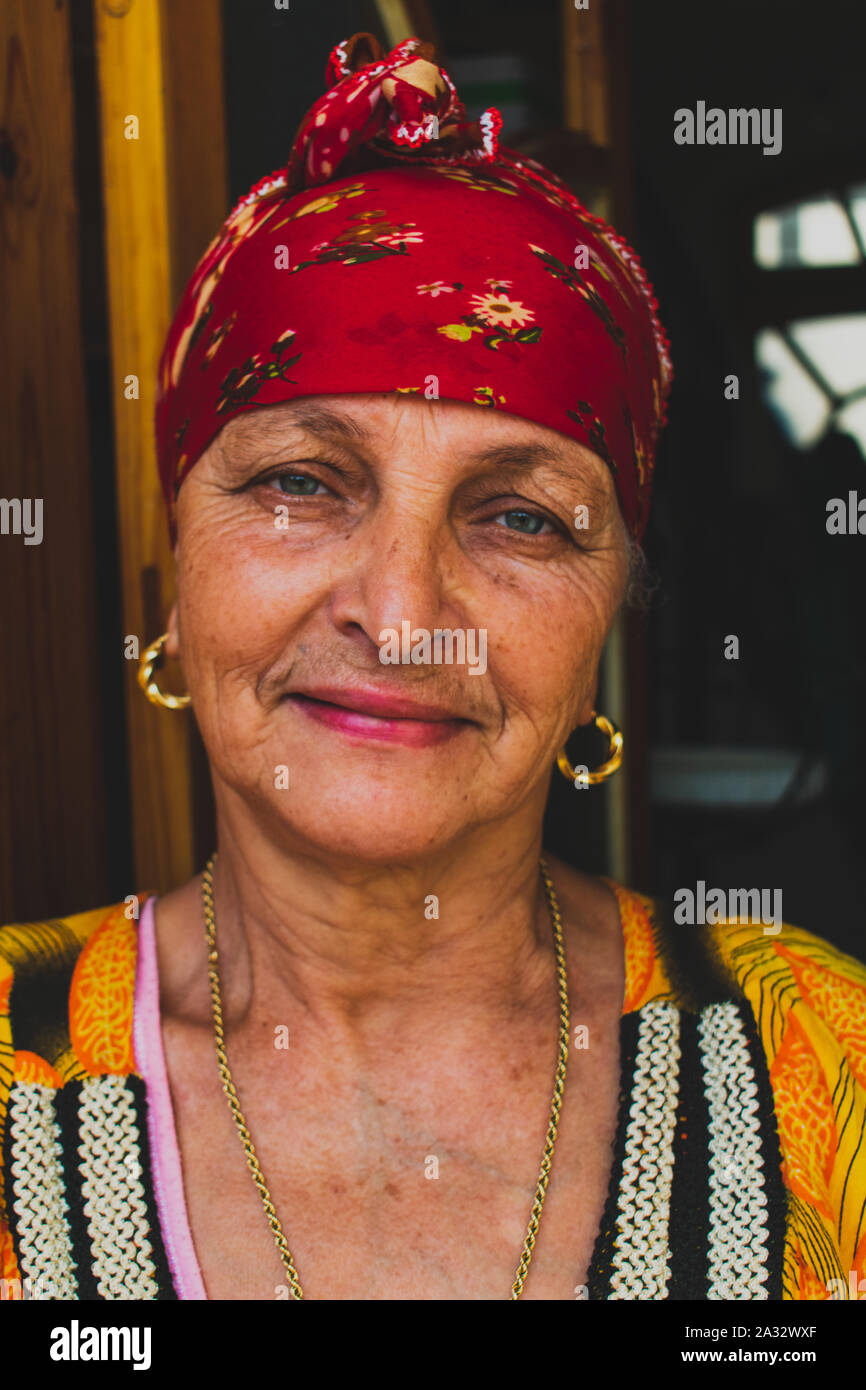 Belle vieille femme berbère de la région des Aurès aux yeux verts, souriant et vêtu du costume traditionnel chaoui foulard. Banque D'Images