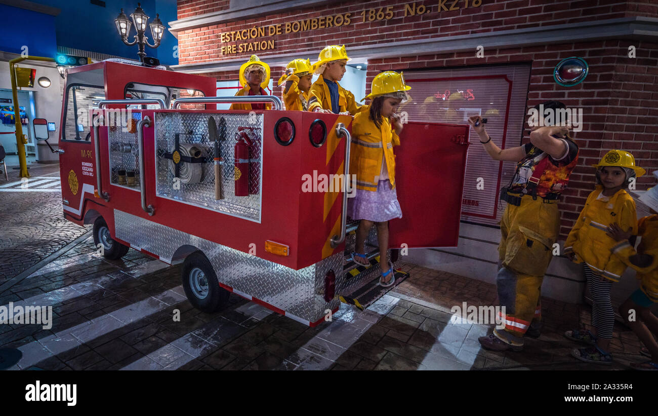 Jeu de rôle enfants heureux les pompiers arrivant à la maquette du dépôt d'incendie Banque D'Images