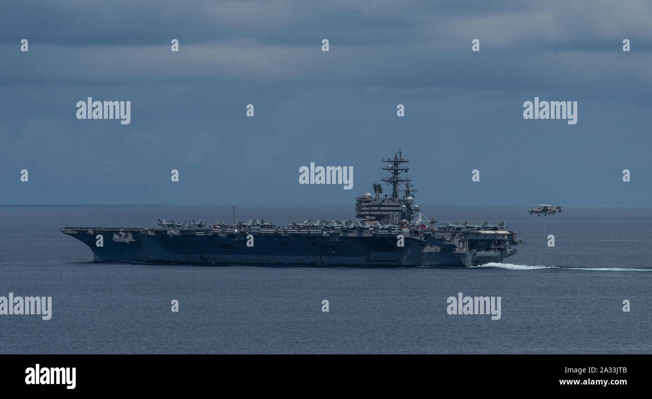 191004-N-PJ626-0003 Mer de Chine du Sud (4 octobre 2019) La Marine a déployé des porte-avions USS Ronald Reagan (CVN 76) récupère un E-2D Hawkeye sur le pont pendant les opérations aériennes. Ronald Reagan, le groupe aéronaval du porte-étendard de 5, fournit une force prête au combat qui protège et défend les intérêts de maritime collective de ses alliés et partenaires dans la région Indo-Pacifique. (U.S. Photo par marine Spécialiste de la communication de masse 2e classe Kaila C. Peters) Banque D'Images