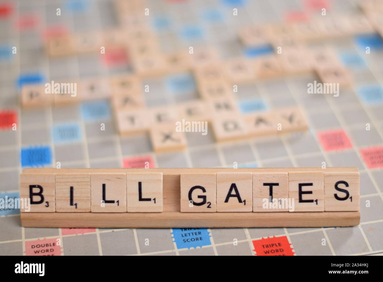 Le nom 'Bill Gates' (fondateur et ancien PDG de Microsoft) en tuiles de SCRABBLE en bois sur une grille. Contexte Une carte vintage, des problèmes de mise au point, l'espace de copie. Banque D'Images