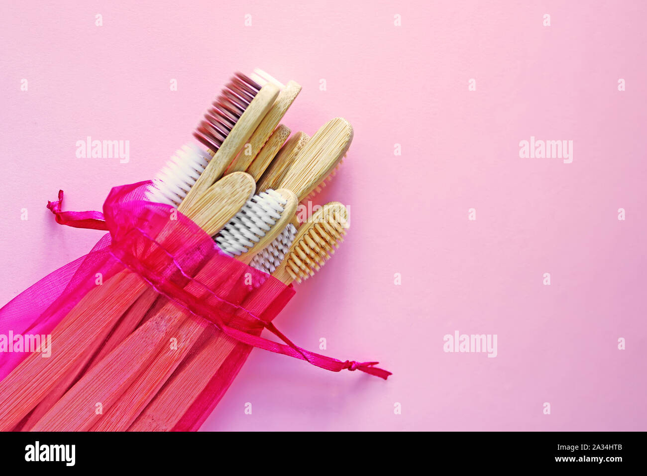 Brosses à dents en bambou dans crimson pochette qui est réutilisable sur fond rose à la mode. Produits respectueux de l'environnement. Eco, zéro déchet et concepts de santé. Mise à plat Banque D'Images