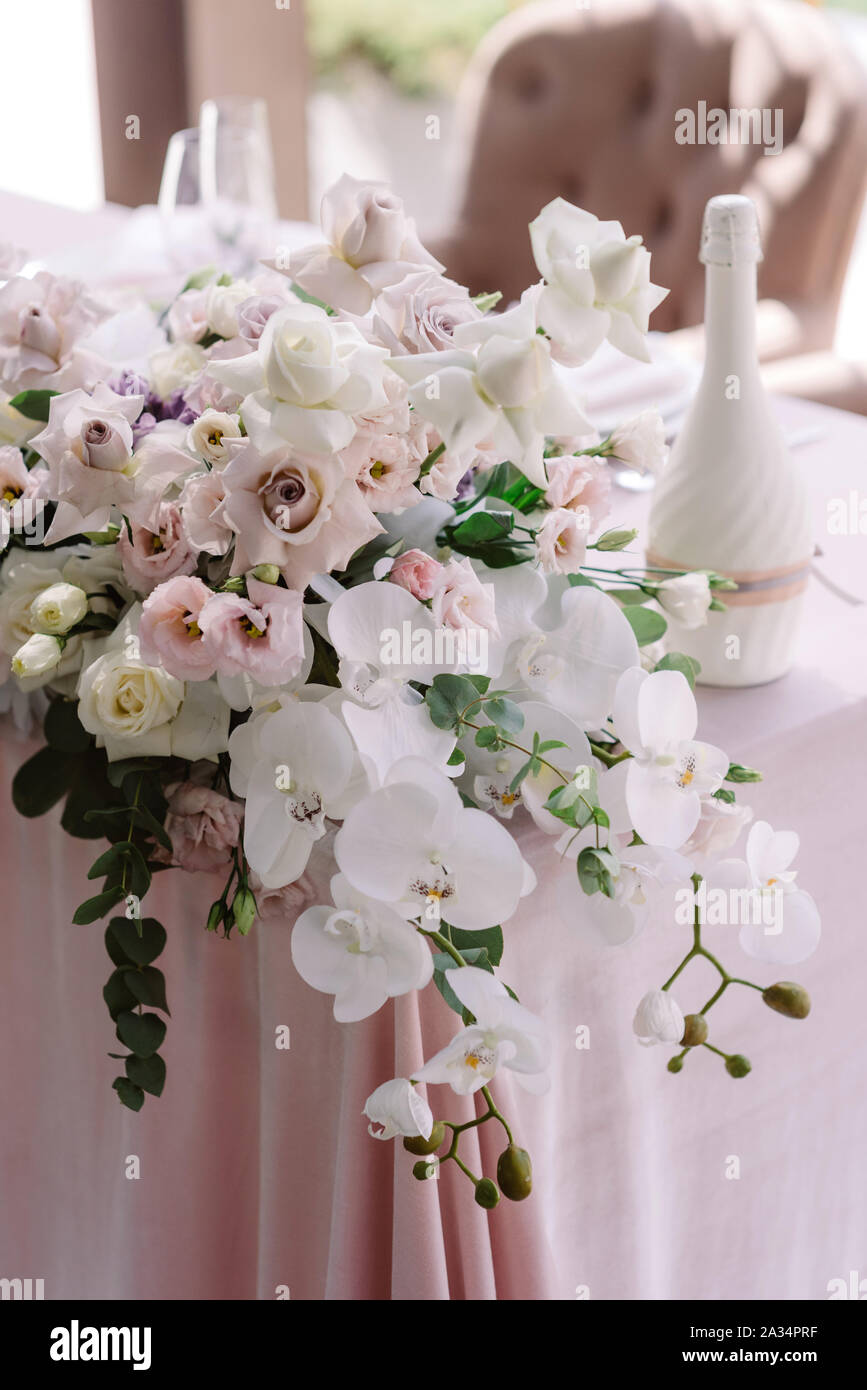 Fleurs de luxe sur le coin de la table de mariage. De superbes orchidées blanches, roses et verts doux rameaux d'eucalyptus Banque D'Images