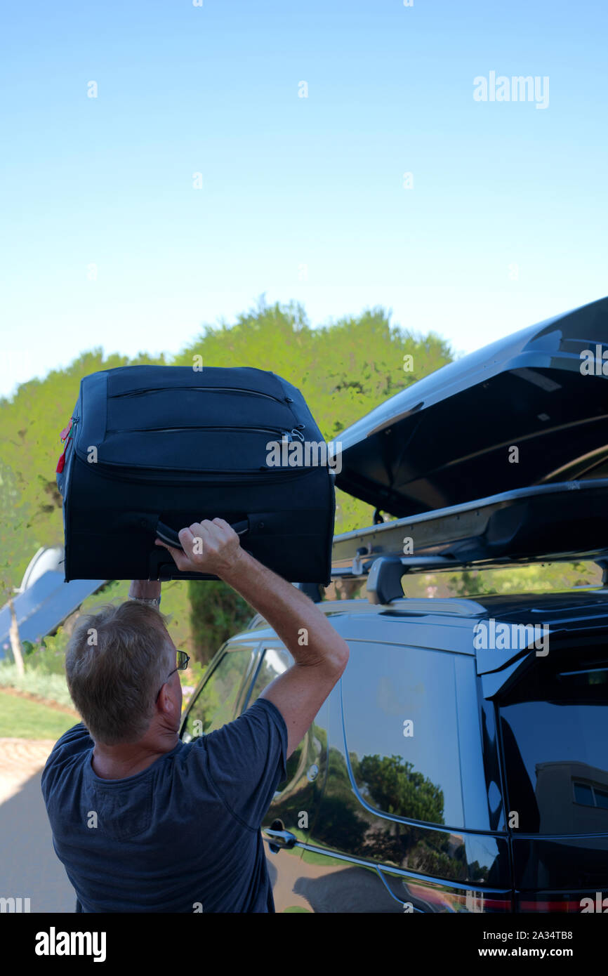 Man loading valise dans un coffre de toit sur le dessus de la voiture Photo  Stock - Alamy
