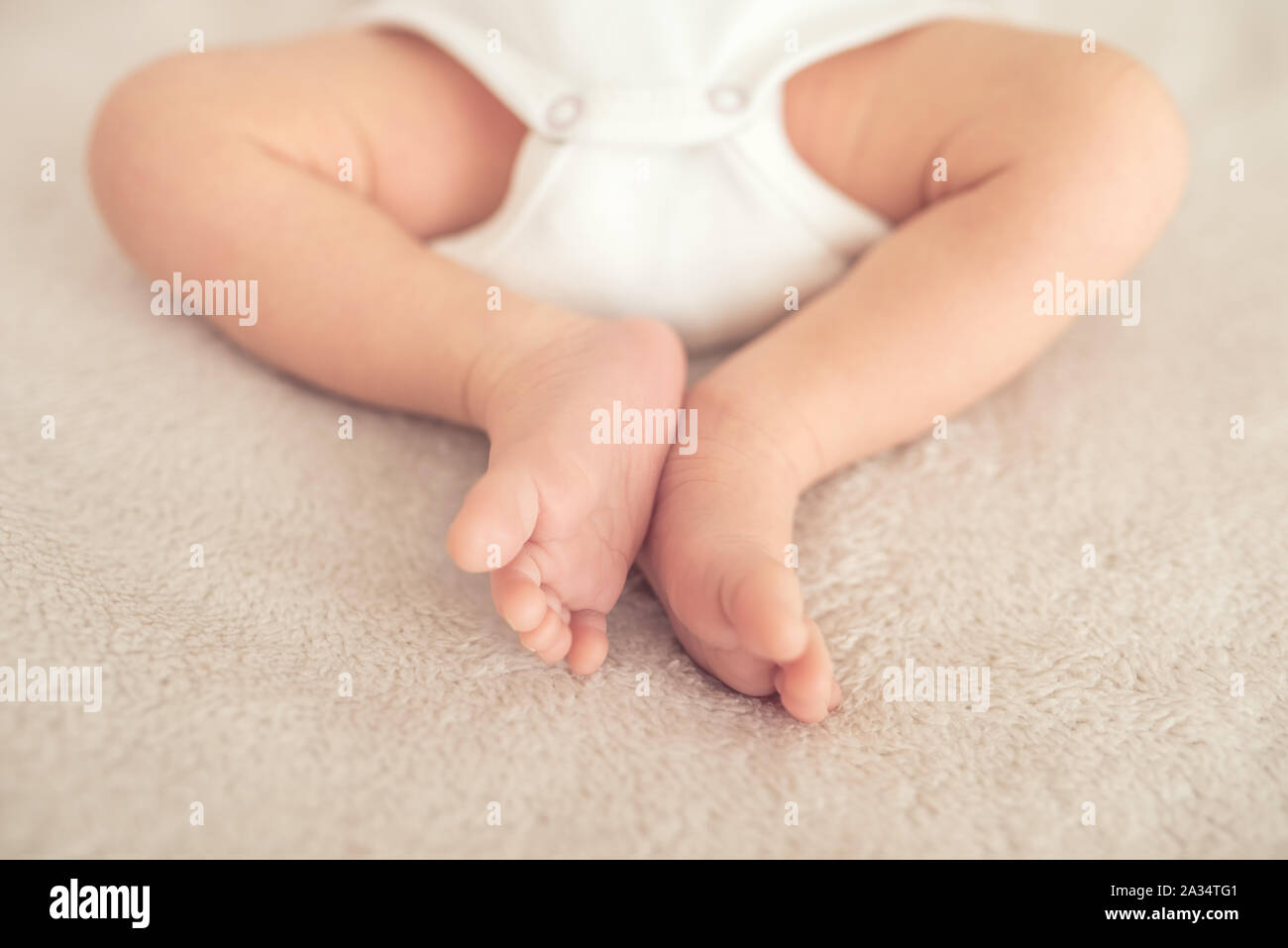 Les jambes de bébé nouveau-né est sleepin sur le lit. Banque D'Images