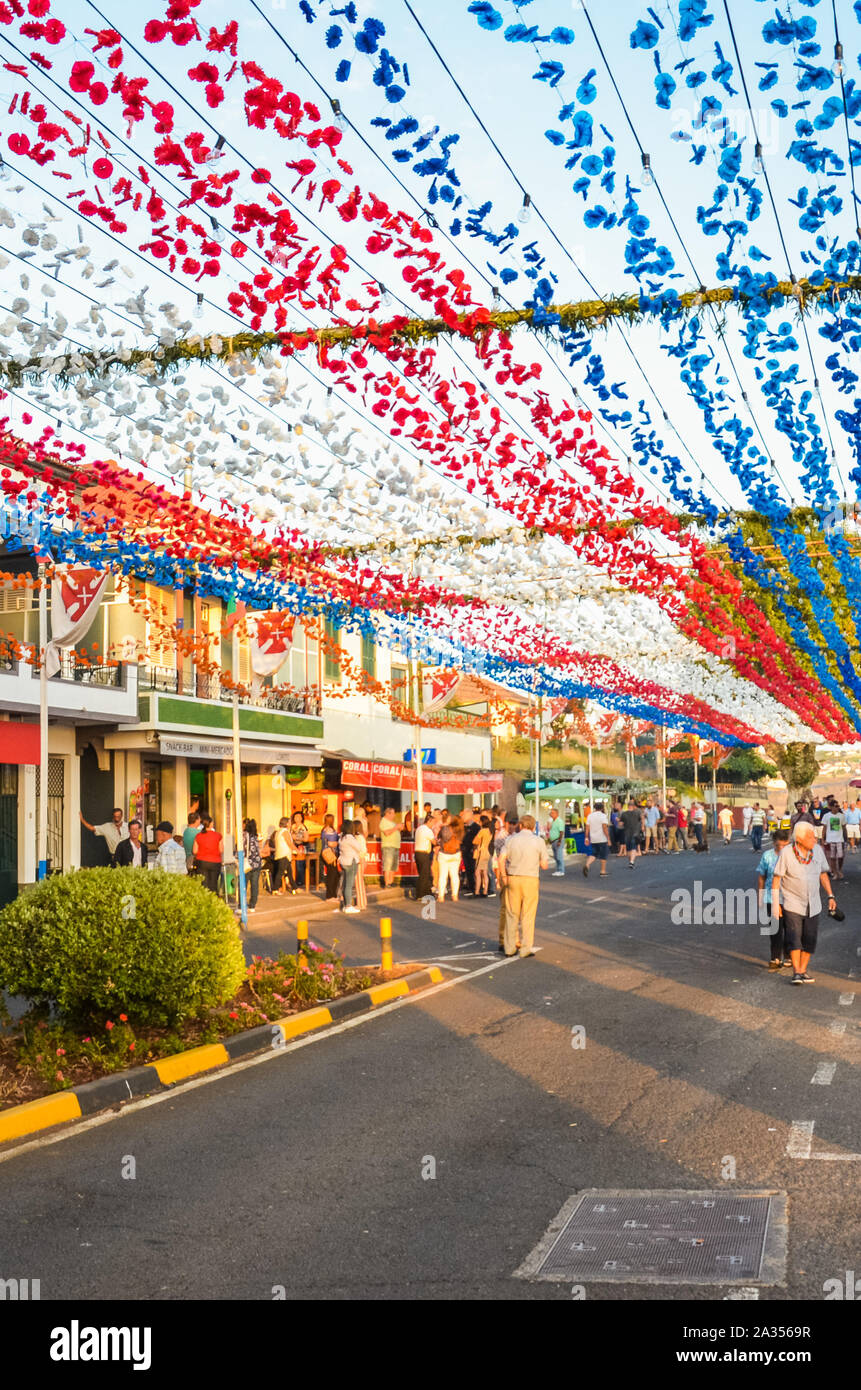 Loreto, Madeira, Portugal - 7 Sep 2019 : décoration de rue colorés au cours de la célébration de la fête religieuse. Fleurs en papier suspendu dans l'air. Les gens célébrant, s'élève avec de la nourriture. Banque D'Images