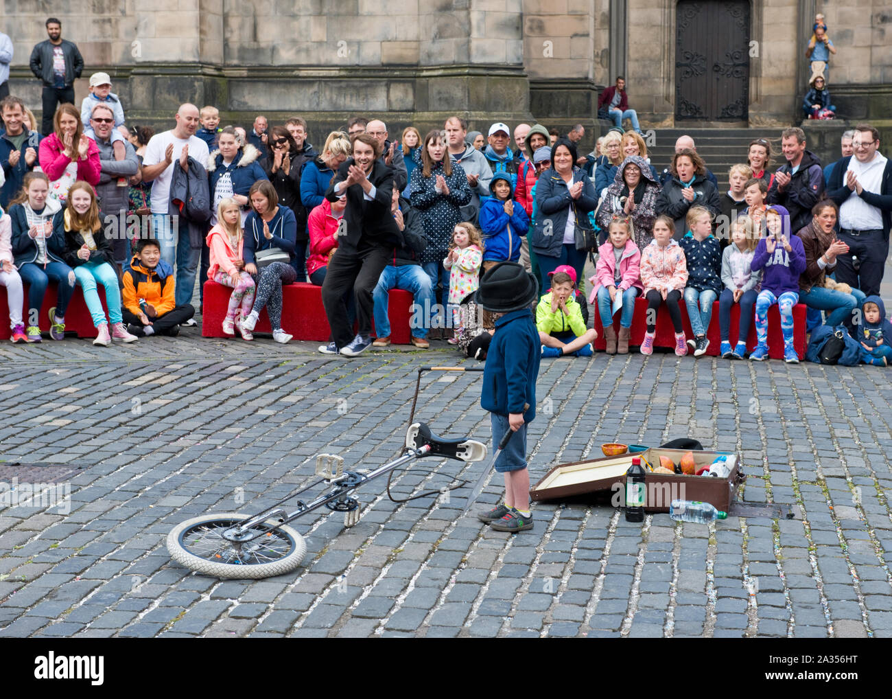 Jeune garçon de profiter de l'auditoire participant à la loi de la rue. Edinburgh Fringe Festival Banque D'Images