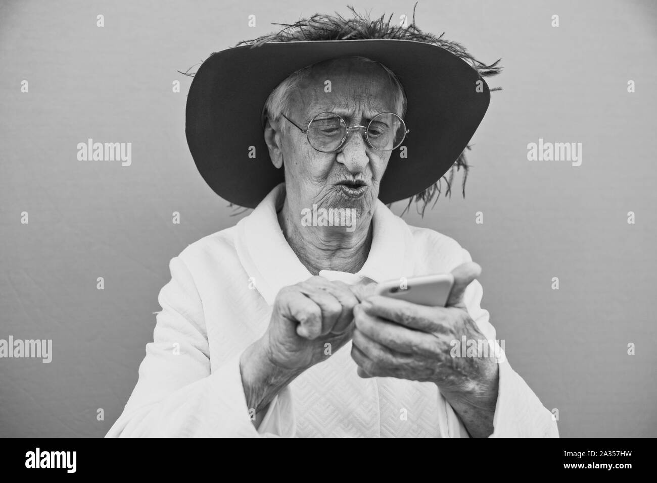 Drôle de grand-mère les portraits. La haute vieille femme, en interaction avec un smartphone. Concept a propos de l'ancienneté Banque D'Images