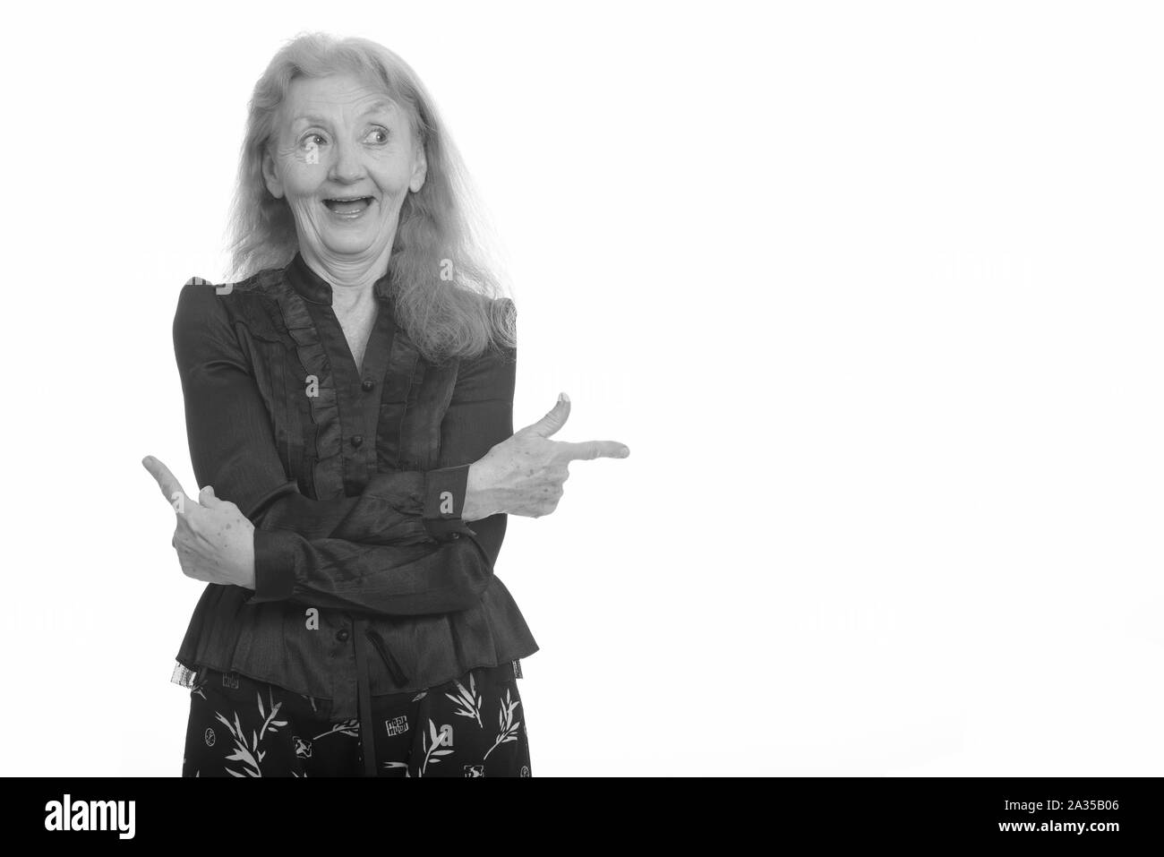 Studio shot of happy businesswoman smiling and pointant dans des directions différentes Banque D'Images