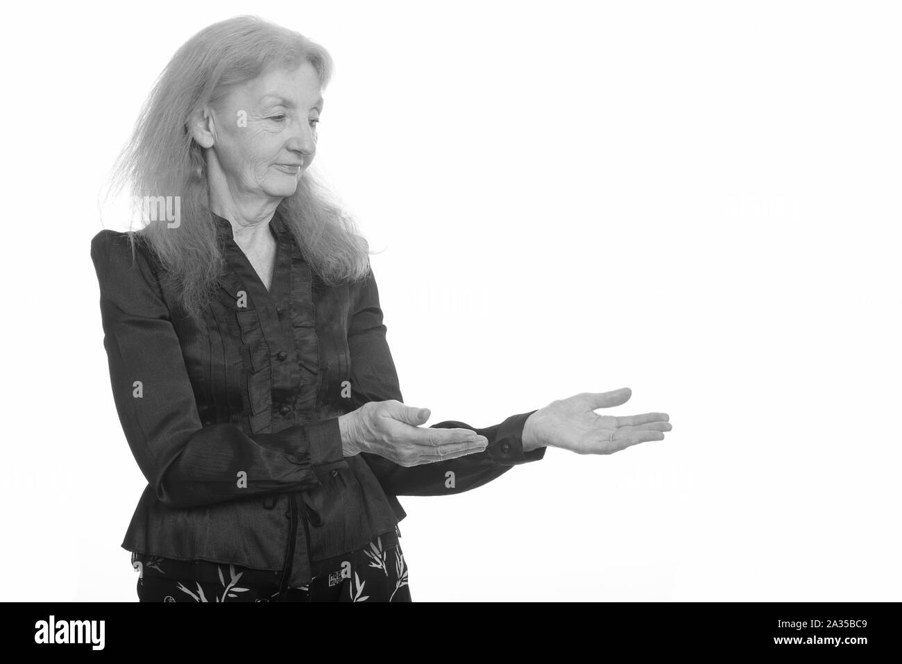 Studio shot of senior businesswoman montrant quelque chose Banque D'Images
