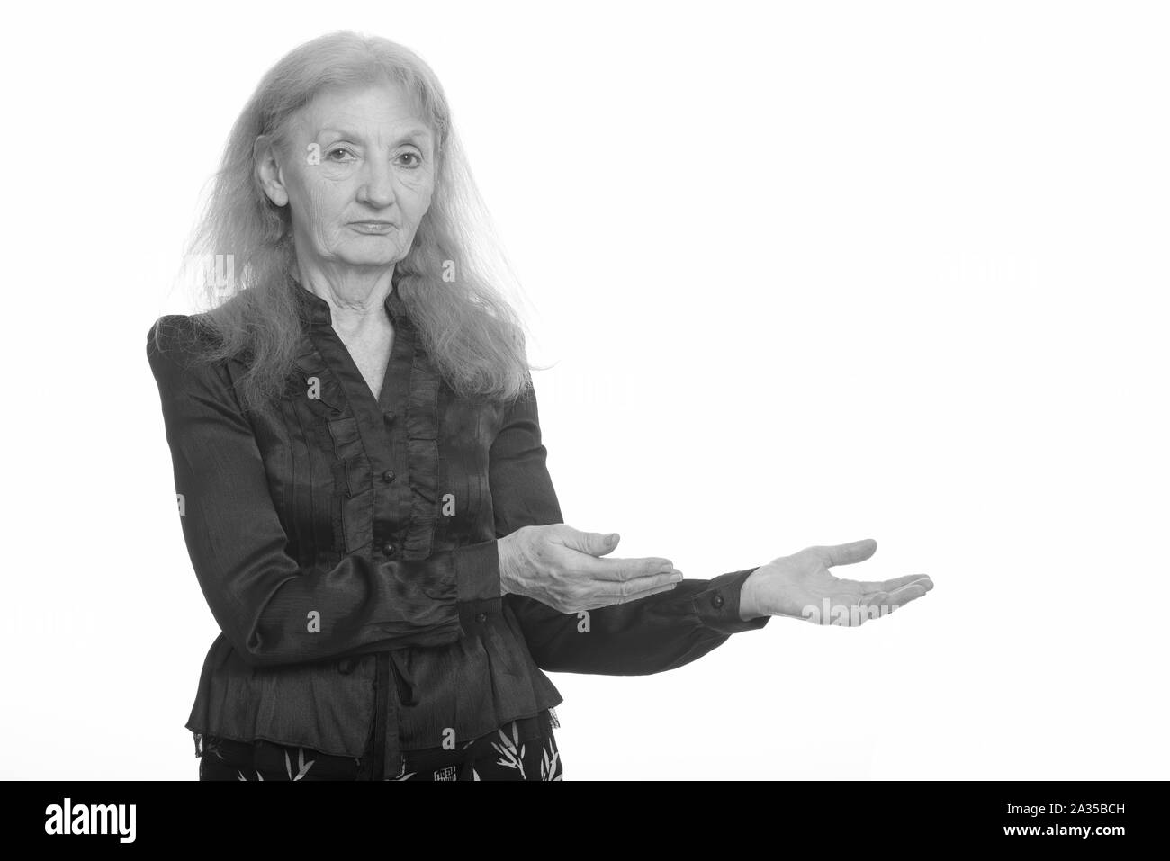 Studio shot of senior businesswoman montrant quelque chose Banque D'Images