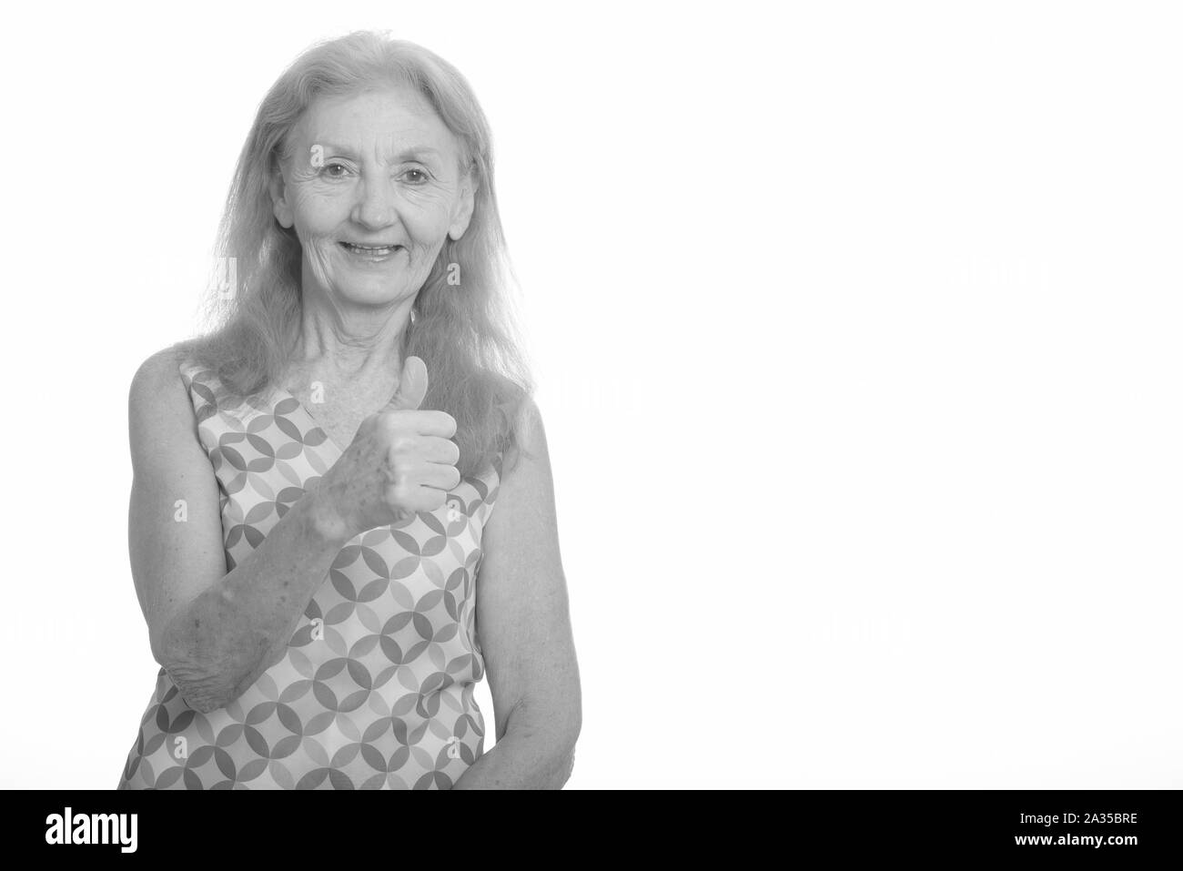 Studio shot of senior woman smiling and giving thumb up Banque D'Images