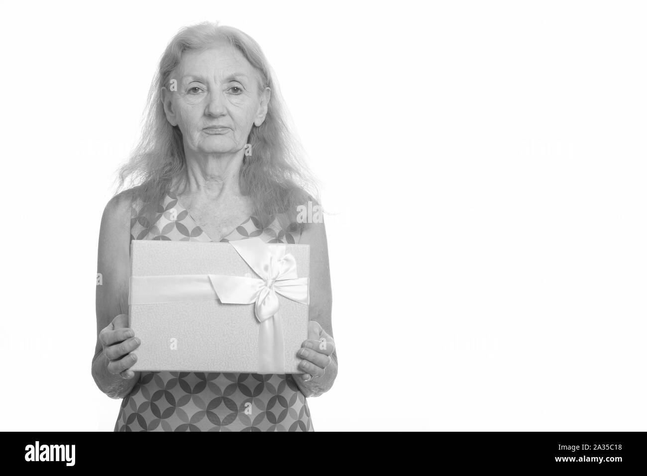 Studio shot of senior woman holding gift box Banque D'Images