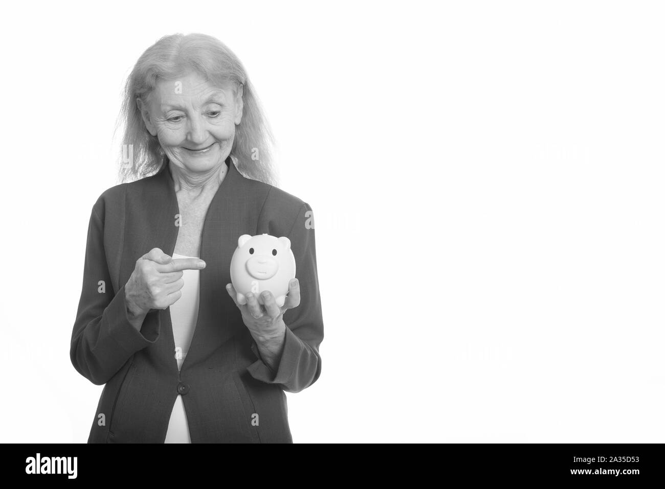 Happy businesswoman smiling while holding piggy bank et montre de l'index Banque D'Images