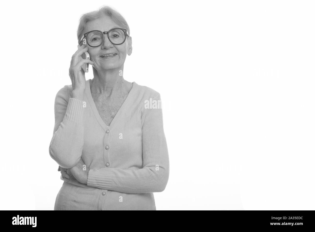 Happy nerd woman smiling while talking on mobile phone Banque D'Images