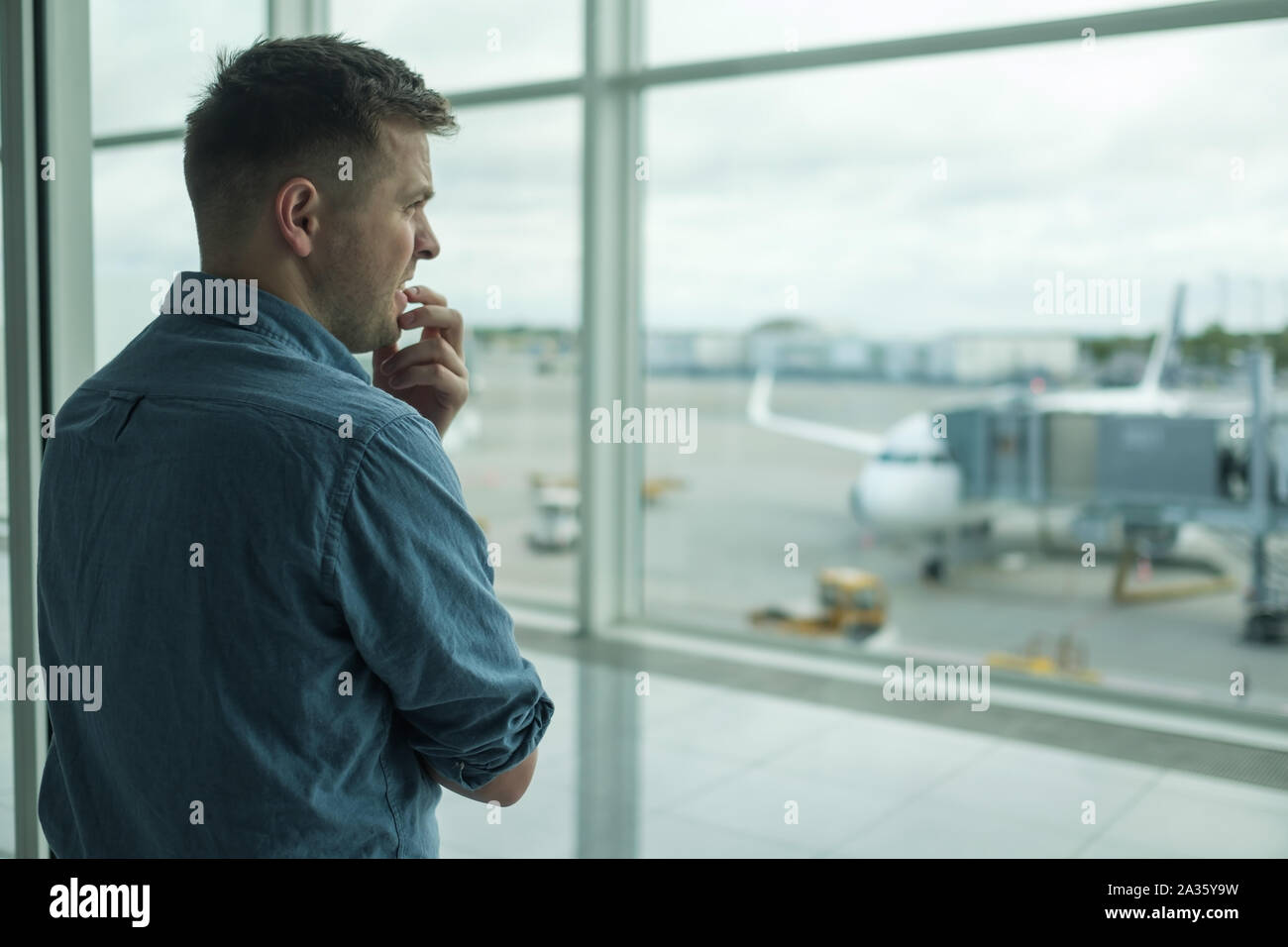 Portrait jeune homme a peur de l'article vol dans la fenêtre terminal près de Banque D'Images