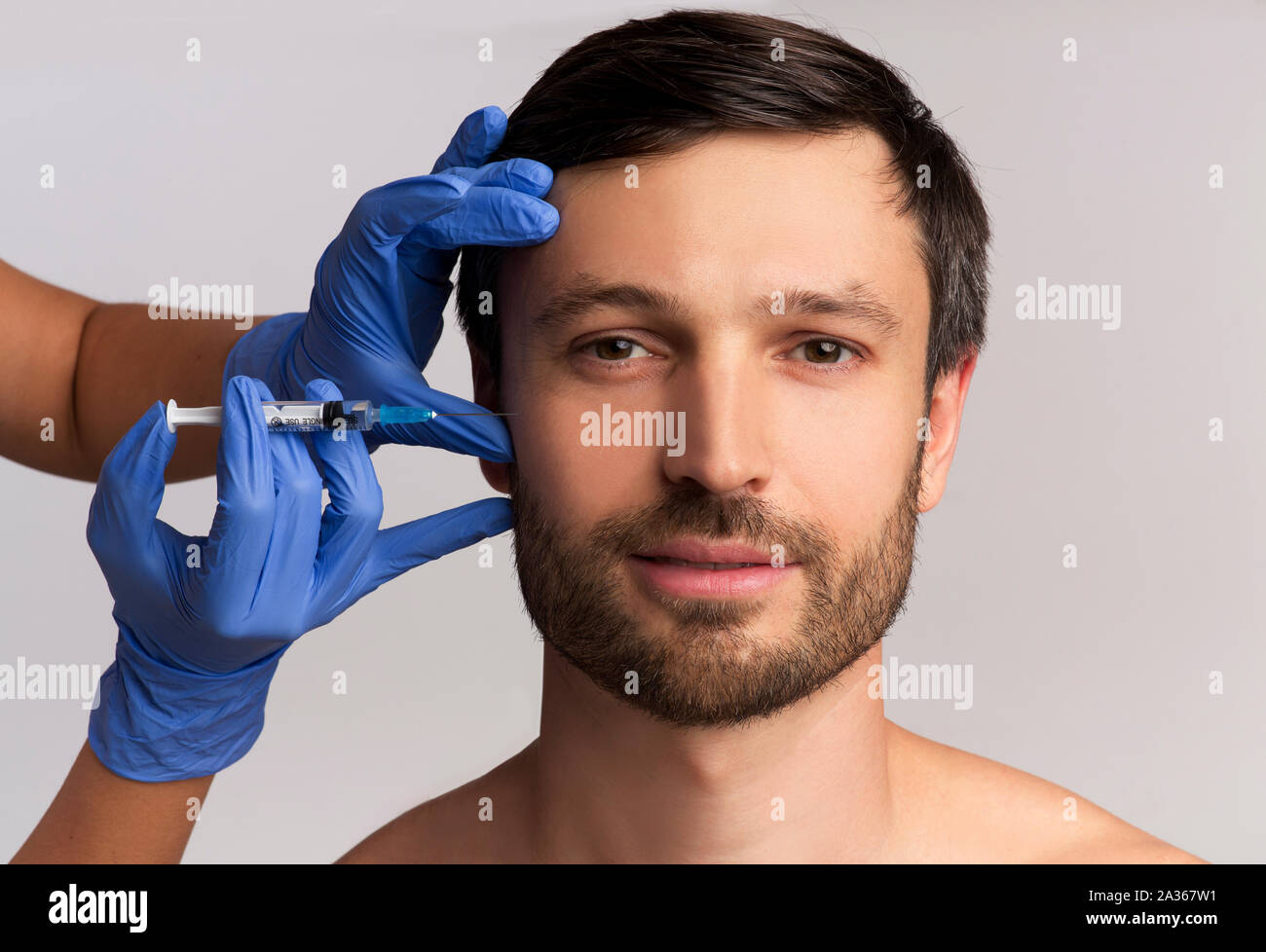 Portrait de Middle-Aged Man Wrinkle-Removing qui reçoit l'Injection, Fond blanc Banque D'Images Portrait de Middle-Aged Man Wrinkle-Removing qui reçoit l'Injection, Fond blanc Banque D'Images