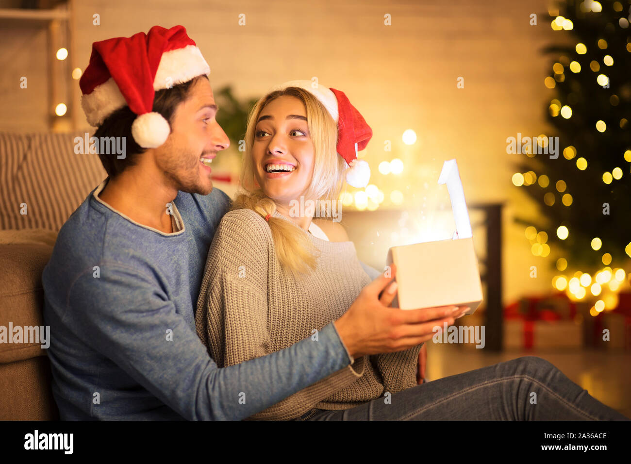 Heureux couple cadeau de Noël dans la salle de séjour Photo Stock - Alamy