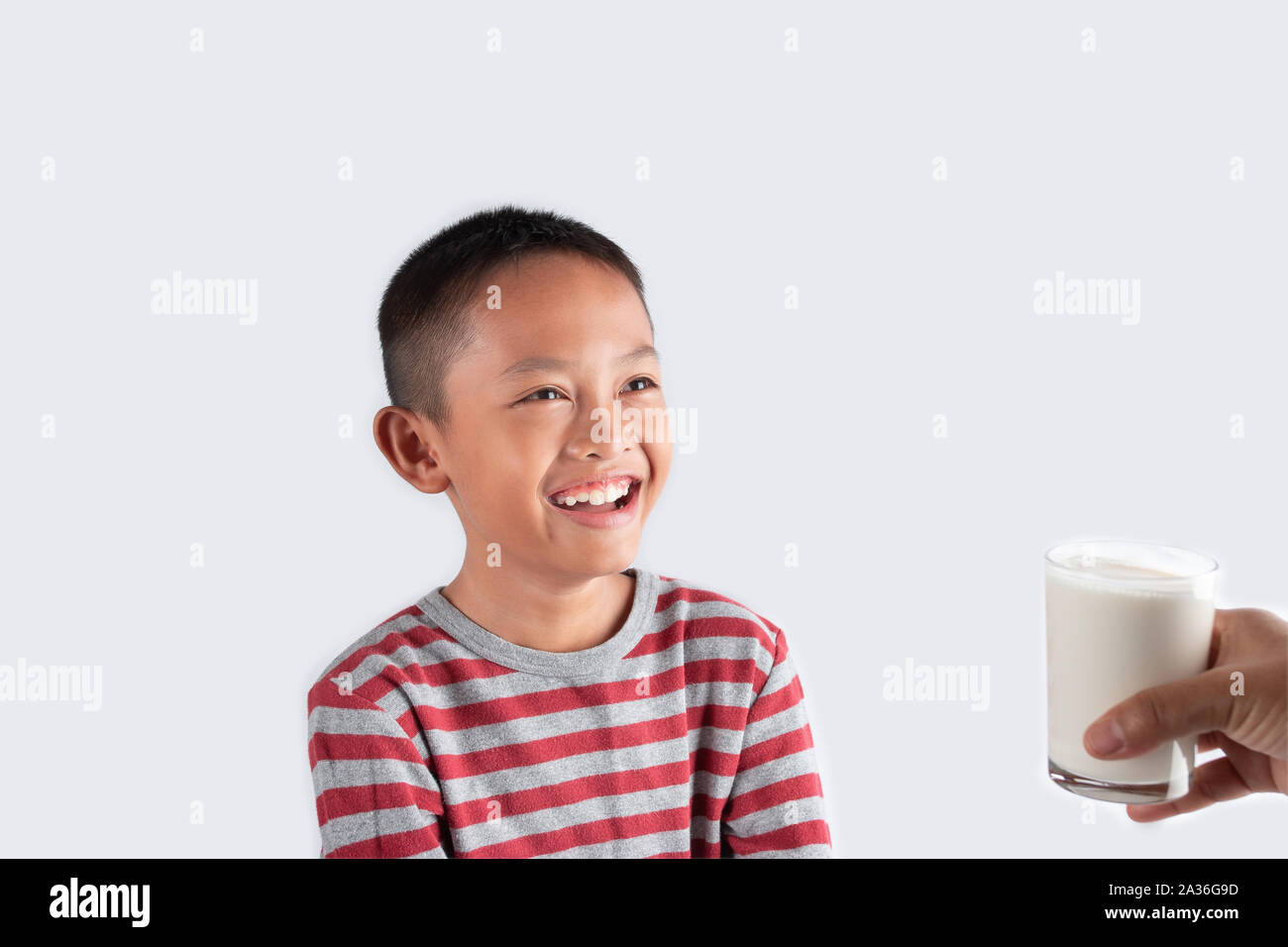 Concept de boire du lait sain, le petit garçon est heureux avec un verre de lait a reçu d'un parent. Banque D'Images