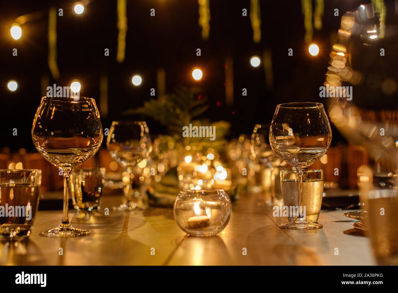 Set Table pour un mariage en plein air le soir. En soirée, fairy lights. Banque D'Images