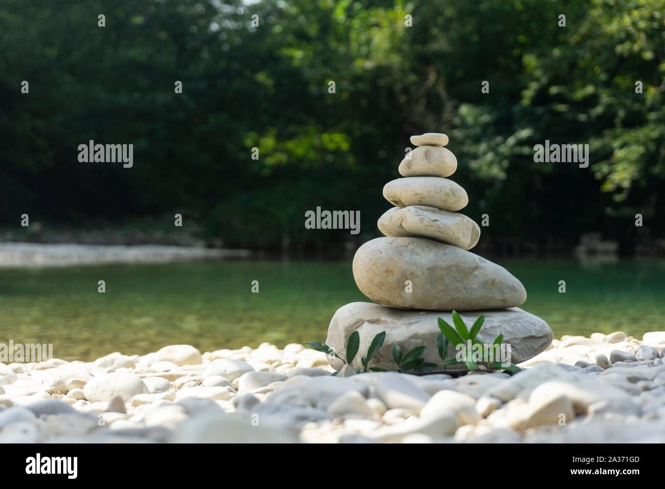 L'harmonie, l'équilibre et la simplicité concept. Une pyramide en pierre sur l'arrière-plan d'eau de rivière. De simples cailloux poise, rock sculpture zen, une tour à partir de la rive Banque D'Images