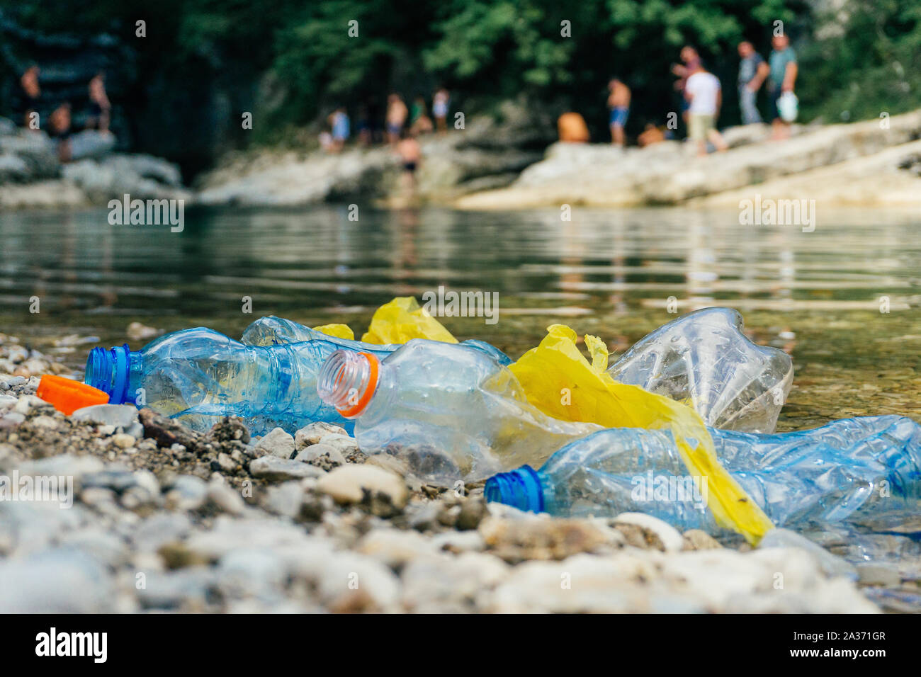 La pollution en plastique dans la rivière. Sacs et bouteilles en ...