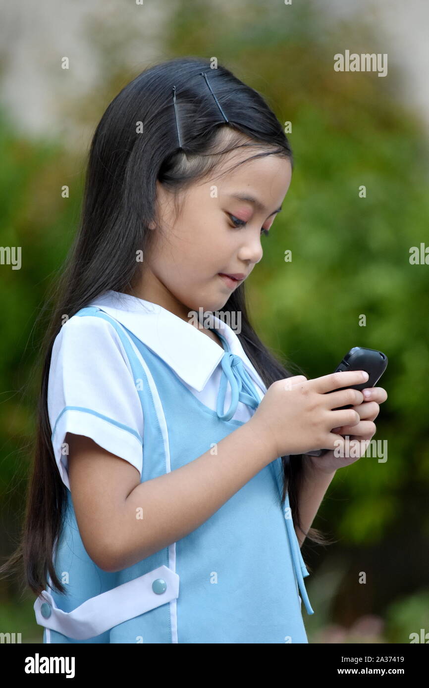 Mignon femelle Student School Girl Wearing School Uniform avec Téléphone Banque D'Images