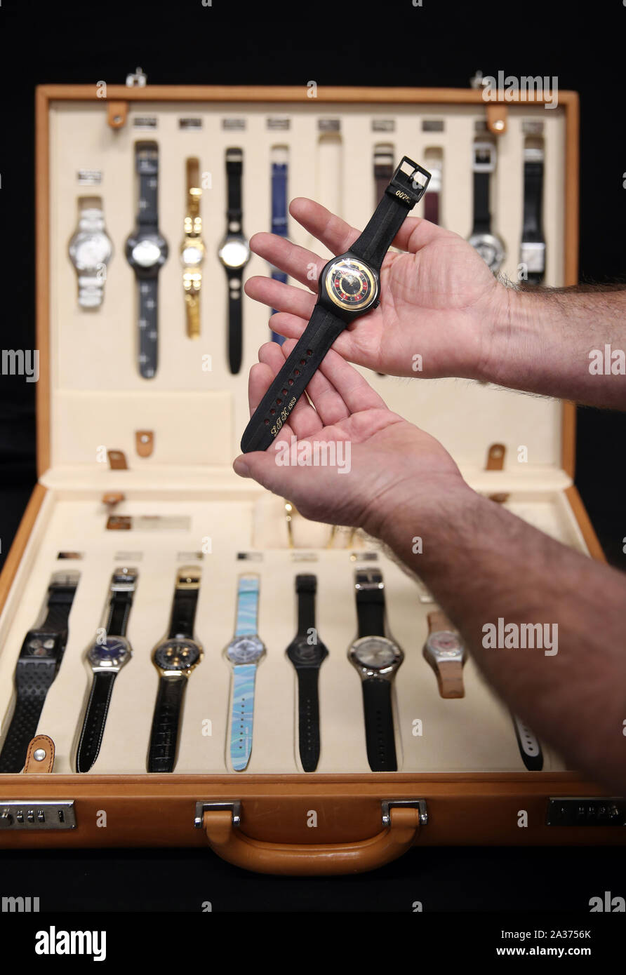 De 0001 sous embargo Lundi 07 octobre Prop Store poster consultant Mike Bloomfield est titulaire d'une montre Swatch pour le film 1989 Permis de tuer en face d'un James Bond Présentation Swatch cas (estimation £2,500-3,000) maintenant montres Swatch de Dr No à mourir un autre jour, au cours d'un essai pour le cinéma à venir du magasin Prop poster vente aux enchères. Banque D'Images