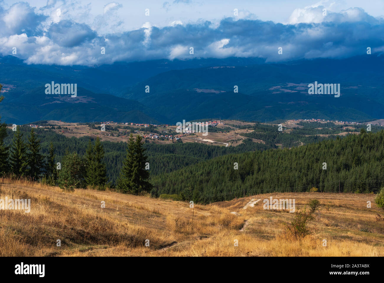 Village bulgare en Konarsko Rhodopes en face de montagne de Rila au cours de journée d'automne nuageux Banque D'Images