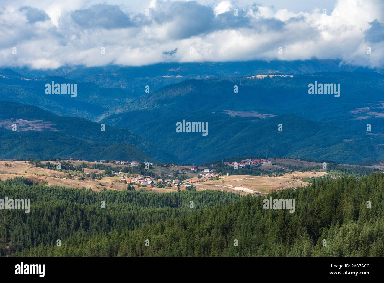 Village bulgare en Konarsko Rhodopes en face de montagne de Rila au cours de journée d'automne nuageux Banque D'Images