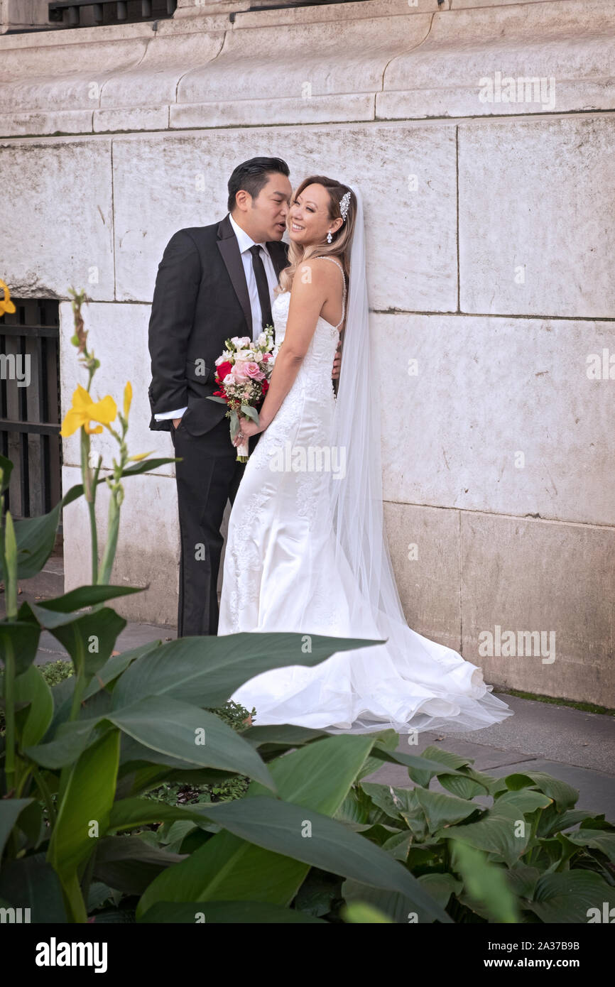 Un couple asiatique partagent un rire tout en posant pour des photos de mariage à l'extérieur de la succursale principale de la bibliothèque de New York à Midtown Manhattan, New York. Banque D'Images