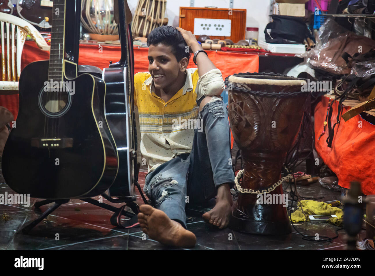 Dans Arambol Goa, Inde, le 9 février 2019 : Jeune garçon travaillant dans la musique souvenirs shop Banque D'Images