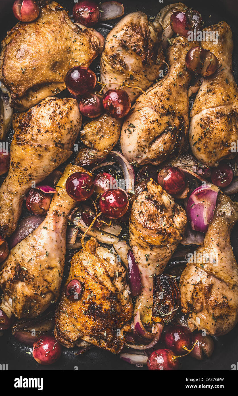 Arrière-plan de l'alimentation des cuisses de poulet grillées pilons avec l'oignon rouge et le raisin, vue du dessus Banque D'Images