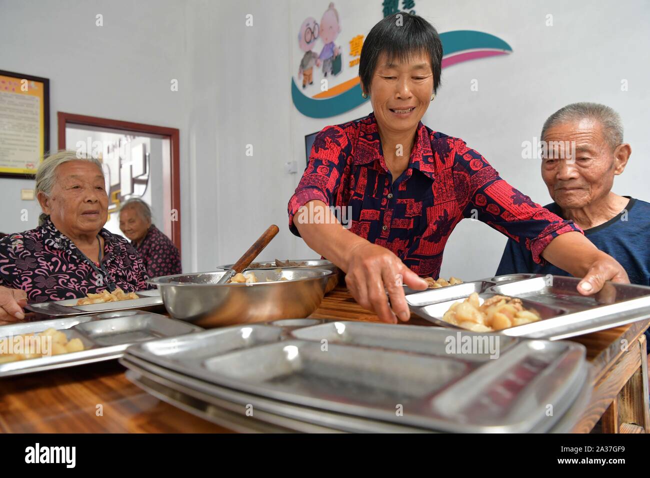 (191006) -- NANCHANG, le 6 octobre 2019 (Xinhua) -- un membre du personnel sert un repas pour les personnes âgées dans une maison de retraite dans le village de Qianjin Nanchang County à Nanchang City, capitale de la Chine de l'est la province, le 6 octobre 2019. Un total de 103 centres de services de soins aux personnes âgées ont été fixées jusqu'ici à Nanchang County grâce à des efforts conjoints des autorités locales, les entreprises et les fonds de bien-être, comme un moyen de rendre accessibles les services de repas dans les régions rurales de résidents seniors. Deux des repas gratuits sont offerts par jour pour les personnes âgées qui sont vides et de vivre sur les 'Cinq garanties" (senior ou handicapées una Banque D'Images