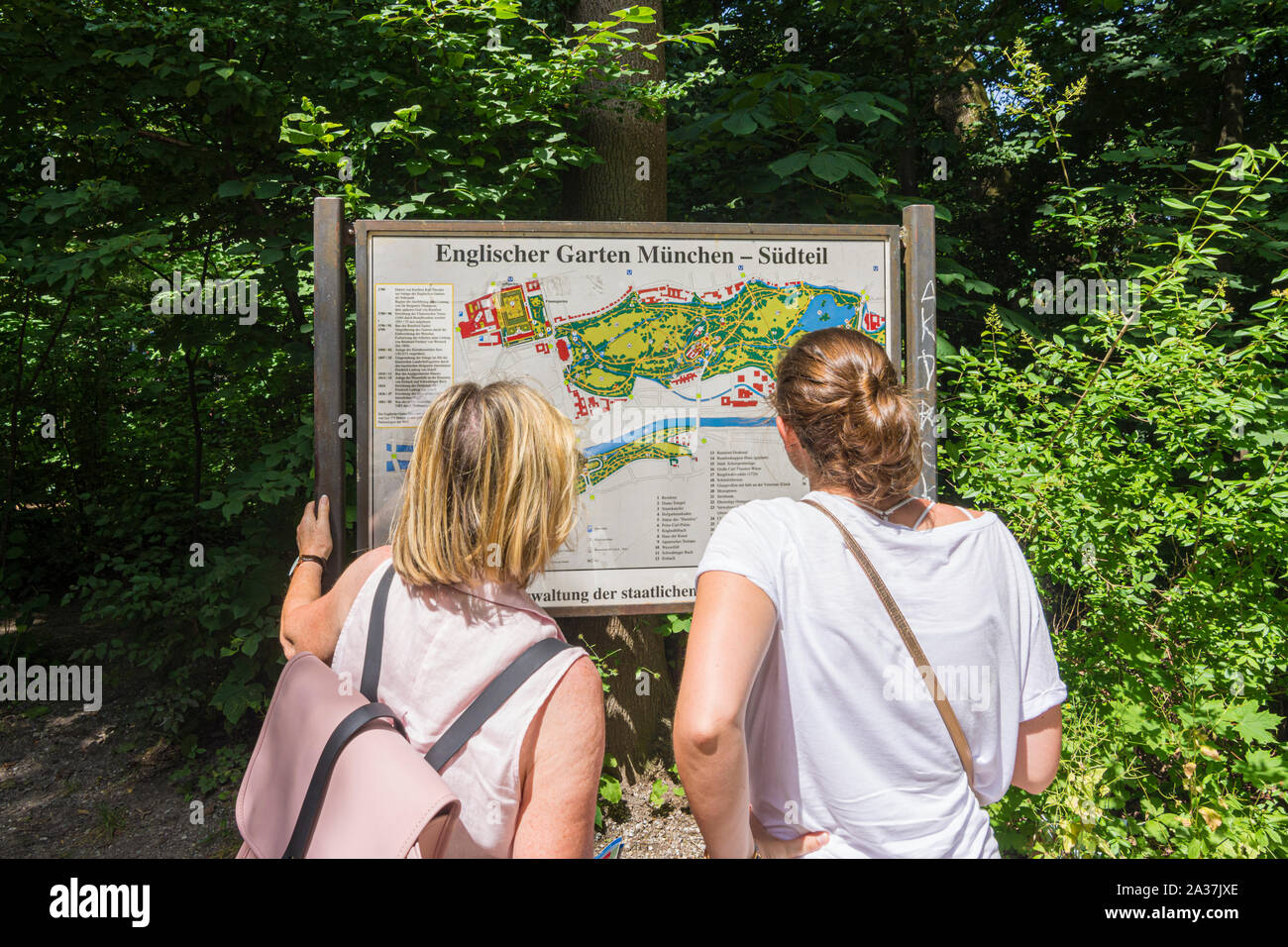 Les touristes en regardant une carte de l'Englischer Garten, Munich, Bavière, Allemagne Banque D'Images