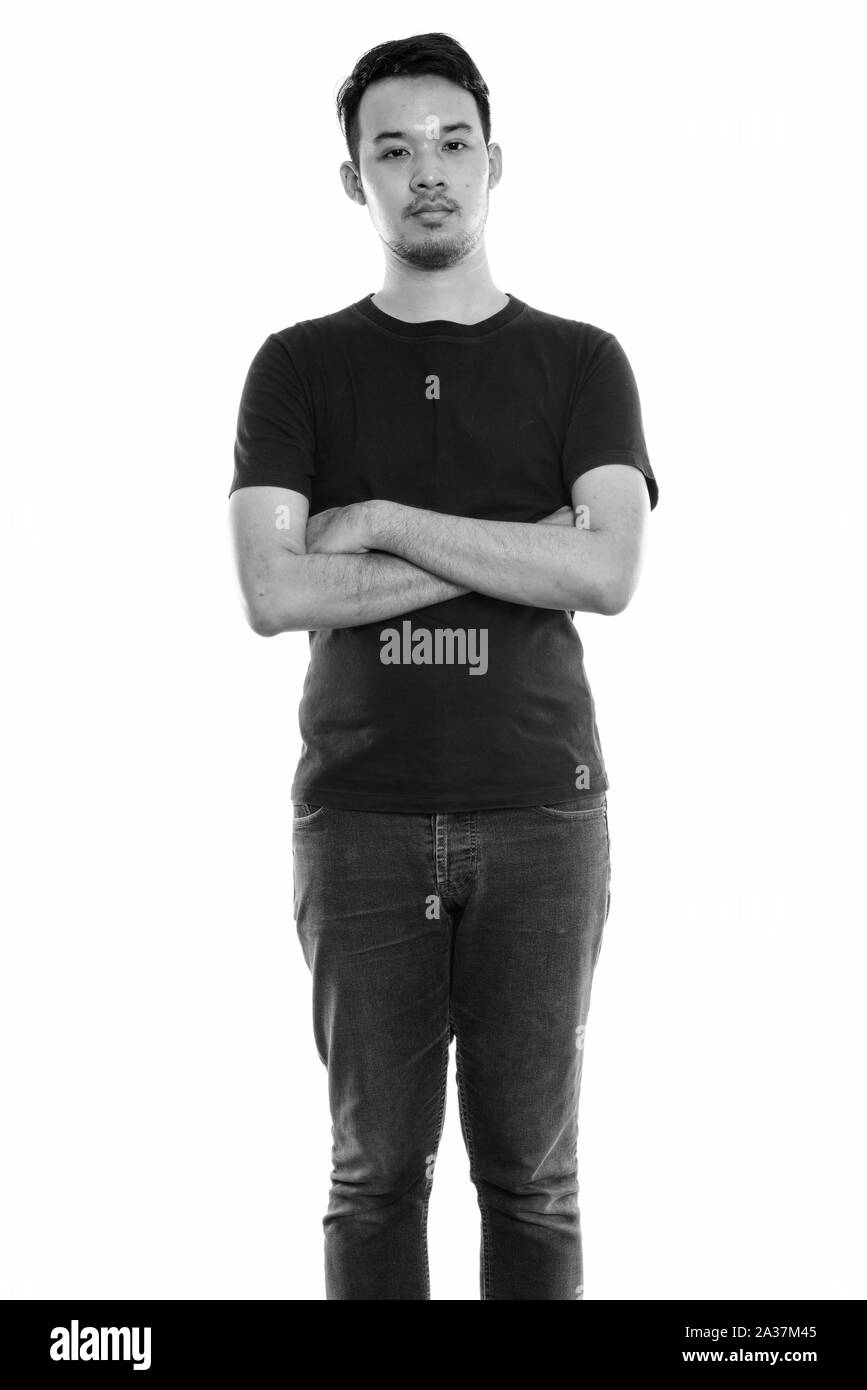 Studio shot of young Asian man standing with arms crossed Banque D'Images Studio shot of young Asian man standing with arms crossed Banque D'Images