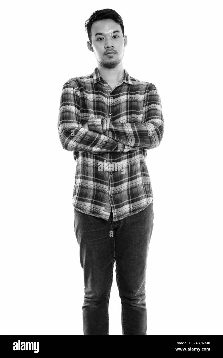 Studio shot of young Asian man standing with arms crossed Banque D'Images Studio shot of young Asian man standing with arms crossed Banque D'Images